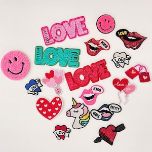 May include: Assortment of iron-on patches with various designs, including hearts, lips, unicorns, smiley faces, and the word "LOVE" in different colors and styles.