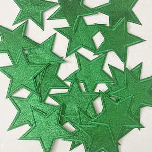 May include: A pile of green glitter star-shaped paper cutouts.