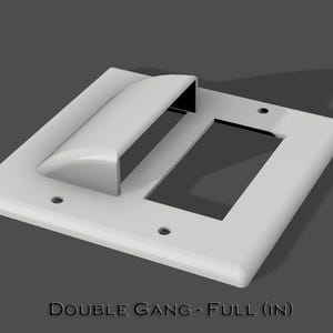 May include: White plastic double gang electrical outlet cover with a single rectangular opening and a rounded rectangular opening. The text "DOUBLE GANG - FULL (IN)" is printed below the cover.