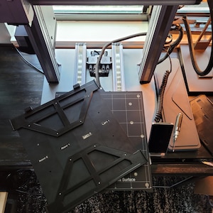 May include: A black 3D printer build plate with a grid pattern and labels for "Left 1", "Left 2", "Right 1", and "Right 2". The plate is on a black surface.