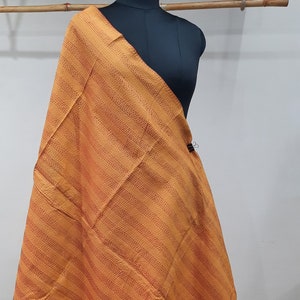 May include: A yellow and orange striped kantha shawl with a subtle pattern of small dots. The shawl is draped over a dress form.
