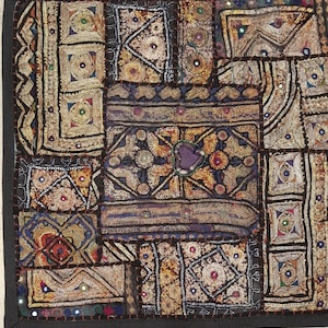 May include: A colorful patchwork quilt with intricate embroidery and sequins. The quilt is made of various fabrics in shades of brown, gold, purple, and blue. The quilt is framed with a black border.