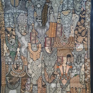 May include: A black tapestry with a patchwork design featuring intricate embroidery in silver, gold, and black thread. The tapestry is made up of various shapes and sizes of fabric, creating a unique and textured look.