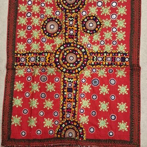 Può includere: Tessuto rosso con ricami intricati e dettagli a specchio. Il design presenta un motivo centrale a forma di croce con motivi circolari e floreali. Il bordo è rosso scuro con cuciture dettagliate. Il tessuto misura circa 61 cm per 61 cm.