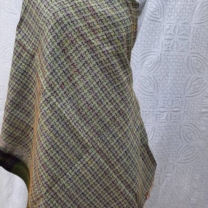 May include: A green and black kantha quilt with a geometric pattern. The quilt is made of recycled saris and has a fringed edge.