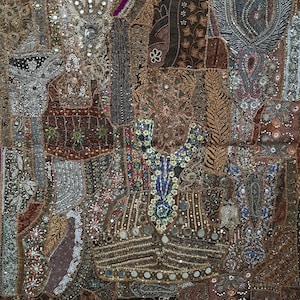 May include: A tapestry wall hanging with a patchwork design featuring various fabrics, embellishments, and sequins. The tapestry is primarily brown and gold with accents of purple, blue, and silver.