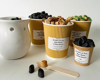 May include: Four small cups filled with soy wax melts in various scents, including coffee beans, caramel vanilla, and peppermint. The wax melts are arranged on a white surface with a white ceramic wax warmer.