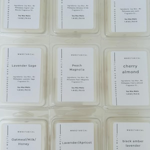May include: Nine rectangular clear plastic containers of MWBOTANICAL handmade soy wax melts arranged in a grid. Each label lists the scent, ingredients, and a weight of 1.8 oz | 75.5 g. Scents include English Lilac Blooms, Whiskey & Oak, and Palo Santo.
