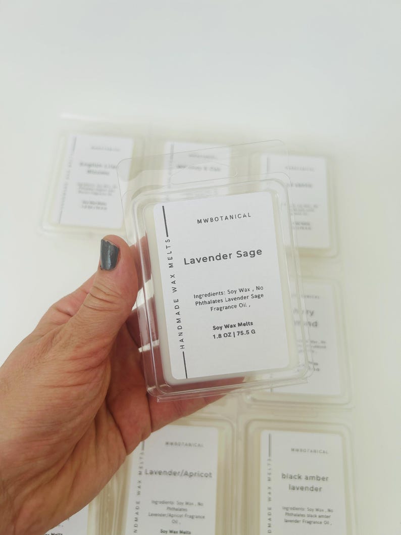 May include: A clear plastic clamshell container holding white wax melts labeled MWBOTANICAL Lavender Sage. The label lists ingredients as soy wax, no phthalates, and lavender sage fragrance oil, with a net weight of 1.8 ounces or 75.5 grams.