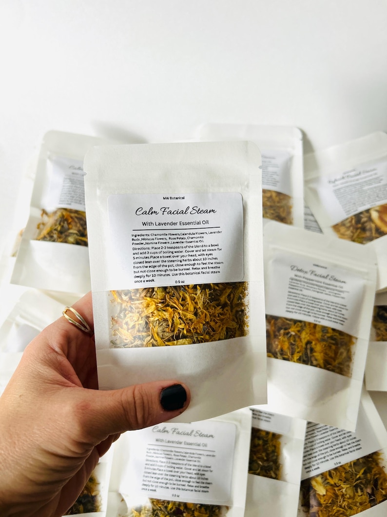 May include: A white paper pouch with a clear window showing dried yellow and orange flower petals. The pouch is labeled "Calm Facial Steam with Lavender Essential Oil" and includes instructions for use. WW Botanical is printed on the pouch.