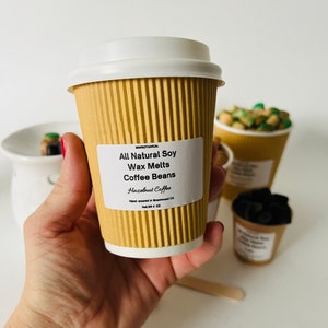 May include: A brown paper cup with a white lid filled with soy wax melts. The label reads "MWBOTANICAL All Natural Soy Wax Melts Coffee Beans Hazelnut Coffee Hand-poured in Brentwood CA Net Wt 4 OZ".