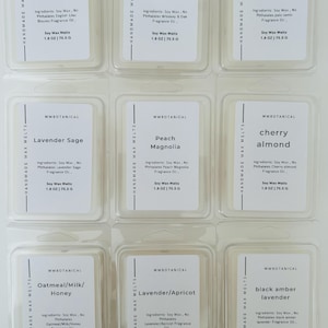 May include: Nine clear plastic clamshell containers of MWBotanical soy wax melts arranged in a grid. Each label lists ingredients, fragrance names like English Lilac Blooms and Whiskey & Oak, and a net weight of 1.8 oz | 75.5 g per unit.