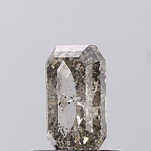 May include: A rectangular-cut gemstone with a clear, grey colour and internal inclusions. The gem has a polished surface and a symmetrical cut, reflecting light. The overall appearance is a mix of transparency and subtle colour variations.