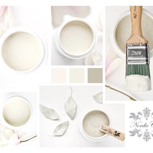 May include: A close-up of a white paint in a jar with a brush and a wooden stick. The paint is in a white jar with a black label that says "Nordic Chic". The paint is surrounded by white flowers and leaves.