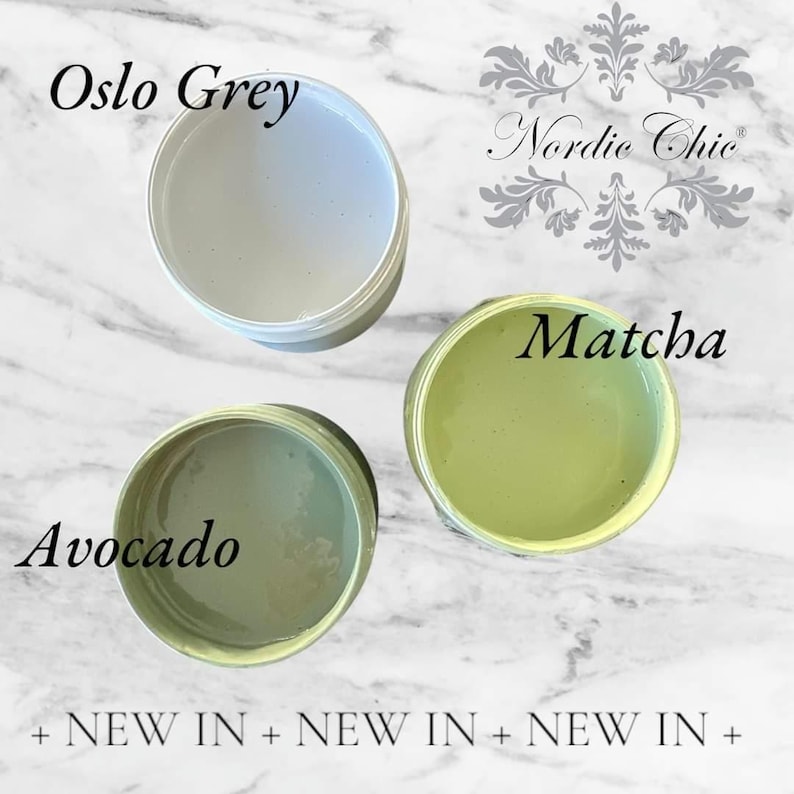 May include: Three paint samples in small jars. The colors are Oslo Grey, Avocado, and Matcha. The jars are on a white marble surface. The text "Nordic Chic" is in the background.