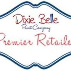 May include: A white logo with blue trim, featuring the text "Dixie Belle Paint Company" and the words "Premier Retailer" in a larger font.