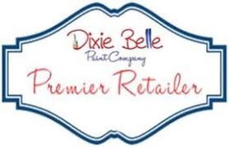 May include: A white logo with blue trim, featuring the text "Dixie Belle Paint Company" and the words "Premier Retailer" in a larger font.