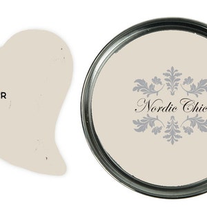 May include: A can of Nordic Chic Plaster paint. The paint is a light beige color. The can has a silver lid and a white label with the words "Nordic Chic" in black.