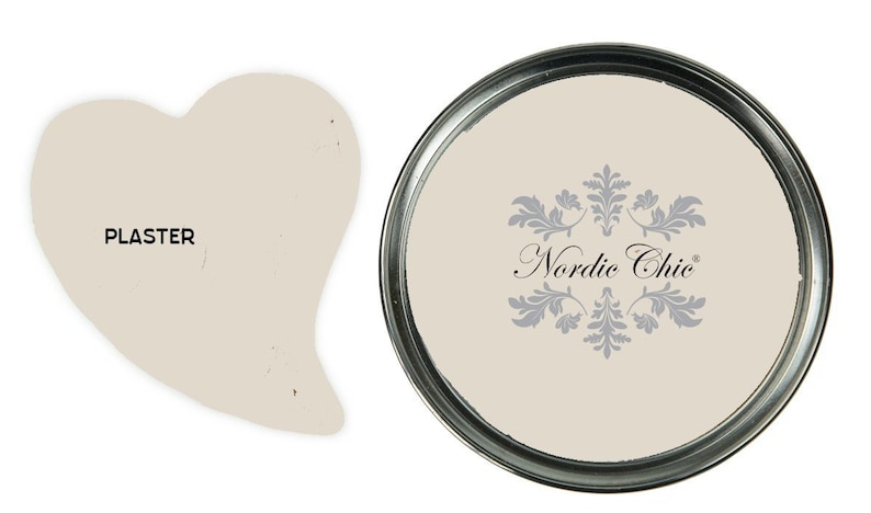May include: A can of Nordic Chic Plaster paint. The paint is a light beige color. The can has a silver lid and a white label with the words "Nordic Chic" in black.