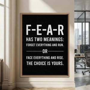 May include: A rectangular wall art piece in a light wood frame featuring a black background with white text that reads: F-E-A-R HAS TWO MEANINGS: FORGET EVERYTHING AND RUN. OR FACE EVERYTHING AND RISE. THE CHOICE IS YOURS.