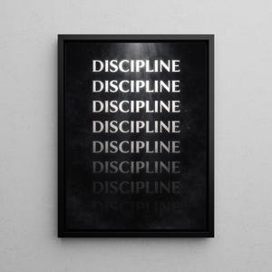May include: A framed black and white print with the word "DISCIPLINE" repeated multiple times in a vertical arrangement. The text is in a bold, sans-serif font, and the background has a subtle, textured appearance.