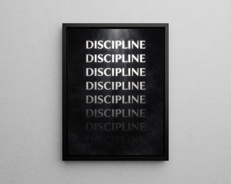 May include: A framed black and white print with the word "DISCIPLINE" repeated multiple times in a vertical arrangement. The text is in a bold, sans-serif font, and the background has a subtle, textured appearance.