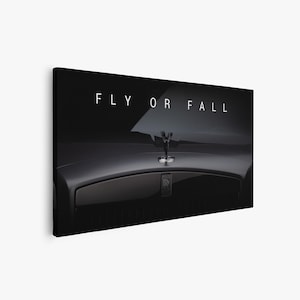 Puede incluir: Impresi&oacute;n en lienzo de un cap&oacute; negro de Rolls-Royce con el emblema Spirit of Ecstasy y el texto "FLY OR FALL" en blanco. La imagen tiene un fondo oscuro y elegante.