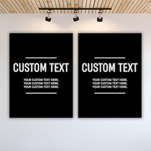 May include: Two black rectangular canvases with white text that reads "CUSTOM TEXT" above the text "YOUR CUSTOM TEXT HERE." The canvases are hanging on a white wall, with a wooden ceiling and track lighting above.