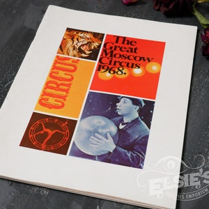 May include: A vintage program for The Great Moscow Circus from 1968. The cover features a tiger, a performer balancing on a trapeze, and a man holding a large ball. The program is printed on white paper with red, orange, yellow, and brown accents.