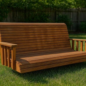 May include: A wooden outdoor bench with a curved seat and backrest. The bench is made of horizontal wooden slats and has armrests. It is set on a grassy lawn with a wooden fence and trees in the background.