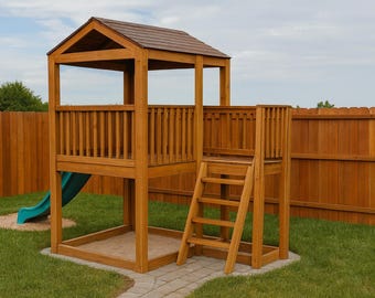 May include: Wooden playset with a brown roof, a blue slide, and a wooden ladder. The playset is set on a green lawn with a wooden fence in the background. The playset has a sandbox area.