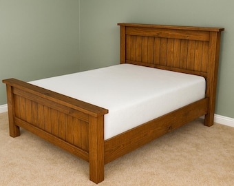 May include: A wooden bed frame with a headboard and footboard. The bed frame is made of stained wood and has a white mattress. The headboard and footboard have a slatted design. The bed is a standard size.