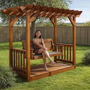 Op de afbeelding: Een houten pergola schommelset met een latten dak en een bank. De structuur is gemaakt van gebeitst hout en staat op een gazon. De schommel heeft een rugleuning en armleuningen. Het ontwerp is rustiek en uitnodigend.