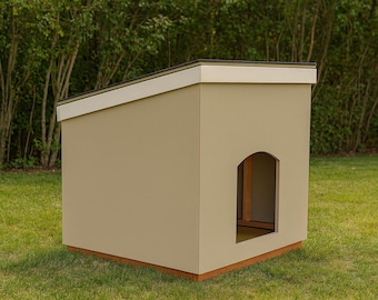 May include: A tan dog house with a slanted roof and an arched doorway. The roof has a white trim, and the base is made of wood. The dog house is set on a green lawn with trees in the background.