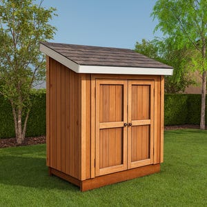 Pode incluir: Um galpão de jardim de madeira com telhado de telhas marrons e acabamento branco. O galpão tem portas duplas e é feito de tábuas de madeira verticais. Ele está em uma base de madeira, cercado por grama verde e árvores.