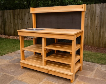 May include: A wooden outdoor play kitchen with a stainless steel sink and multiple shelves. The natural wood-toned structure has a dark pegboard backing and is designed for children's play. It is set on a stone patio.