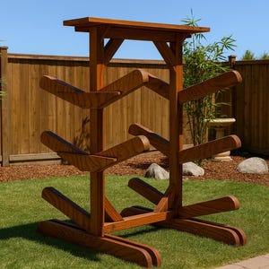 May include: A wooden kayak rack with a dark stain finish. The rack has multiple angled arms for storing kayaks and a flat top. It is set on a green lawn with a wooden fence in the background.