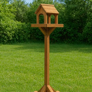 May include: A wooden bird feeder with a house-like structure, perched atop a tall, sturdy post. The feeder has a small roof and arched openings. The post is supported by a four-legged base, all in a natural wood tone, set against a green lawn.