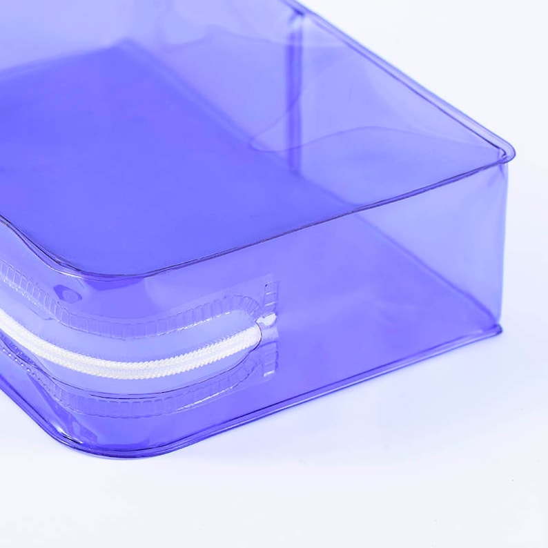 May include: A clear, translucent purple zippered pouch. The pouch is made of a durable plastic material and has a white zipper.