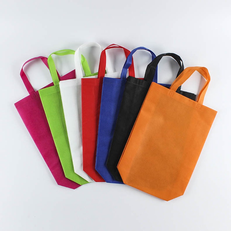 May include: A set of eight reusable shopping bags in various colors, including pink, green, white, red, blue, black, and orange. The bags are made of non-woven fabric and have a simple design with a single handle.