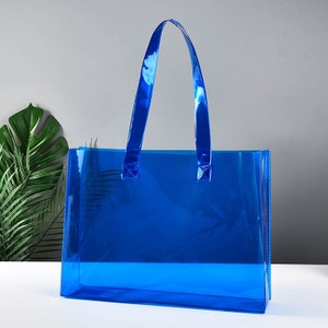 May include: A clear blue tote bag with two handles. The bag is made of a translucent plastic material.