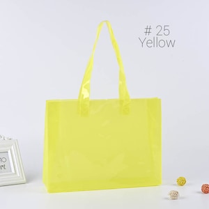 May include: A bright yellow plastic tote bag with clear handles. The bag is empty and has a #25 Yellow label.