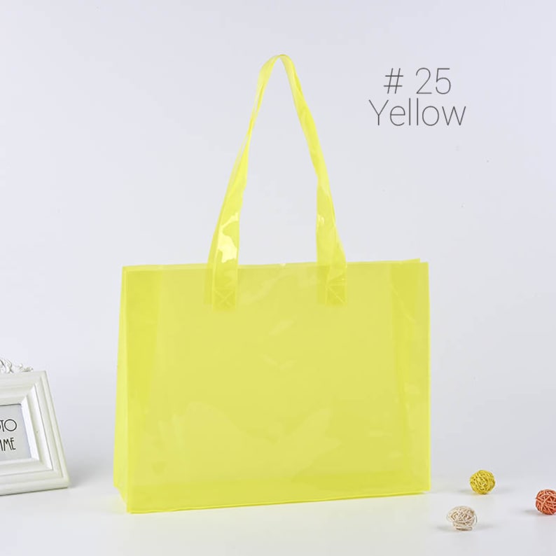 May include: A bright yellow plastic tote bag with clear handles. The bag is empty and has a #25 Yellow label.