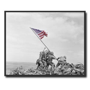 May include: Black and white framed print of the iconic photograph of U.S. Marines raising the American flag on Iwo Jima during World War II. The image shows six soldiers raising the flag on a pole against a cloudy sky.