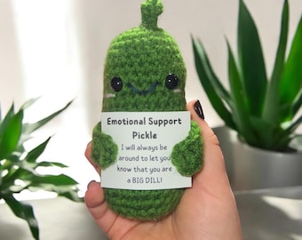 May include: A green crocheted pickle toy holding a card that says "Emotional Support Pickle" and "I will always be around to let you know that you are a BIG DILL!"