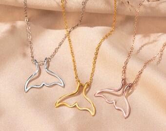 Könnte beinhalten: Vier zarte Halsketten mit Meerjungfrauen-Schwanz-Anhängern. Die Halsketten sind silber, gold, roségold und silber. Die Anhänger sind alle im gleichen Design, aber in verschiedenen Farben.