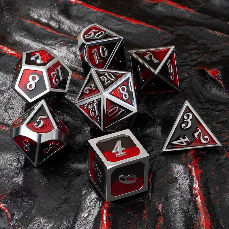 May include: A set of seven polyhedral dice in a variety of shapes. The dice are black with red faces and silver trim. Numbers are displayed in a white, stylized font. The dice are for tabletop gaming.