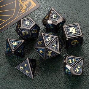 May include: Set of seven black metal dice with gold accents and blue and green iridescent paint. The dice are numbered 1 through 20.