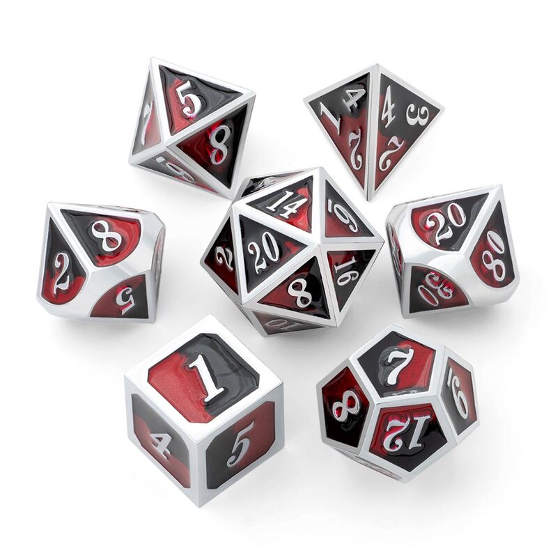 May include: A set of seven polyhedral dice for tabletop games. Each die features a silver frame with black and red faces, displaying white numbers. The dice include a D4, D6, D8, D10, D12, D20, and a percentile die.