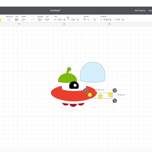 May include: A red, green, yellow and white UFO design with three yellow circles on the bottom. The design is on a white grid background.